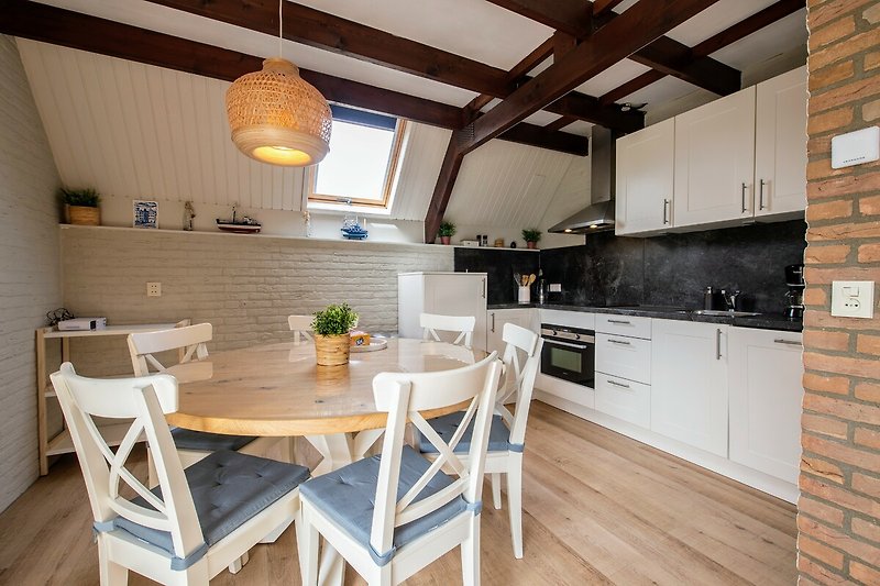Moderne Küche mit Holzmöbeln, Edelstahlgeräten und Esstisch. Gemütliche Atmosphäre.
