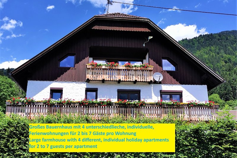 Holzhütte mit Veranda, Bergblick und grüner Landschaft.