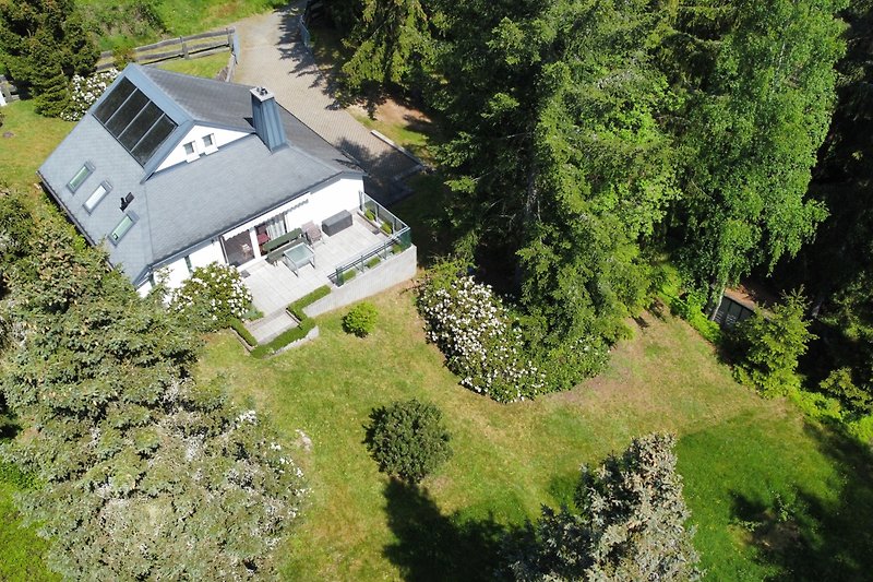 Schönes Haus mit grünem Garten und Bergblick in idyllischer Umgebung.