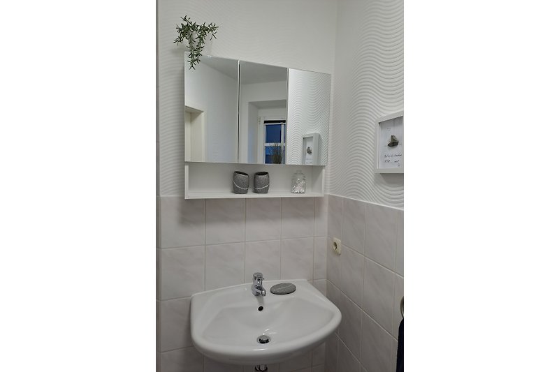 Stilvolles Badezimmer mit modernen Armaturen und Fliesenausstattung.