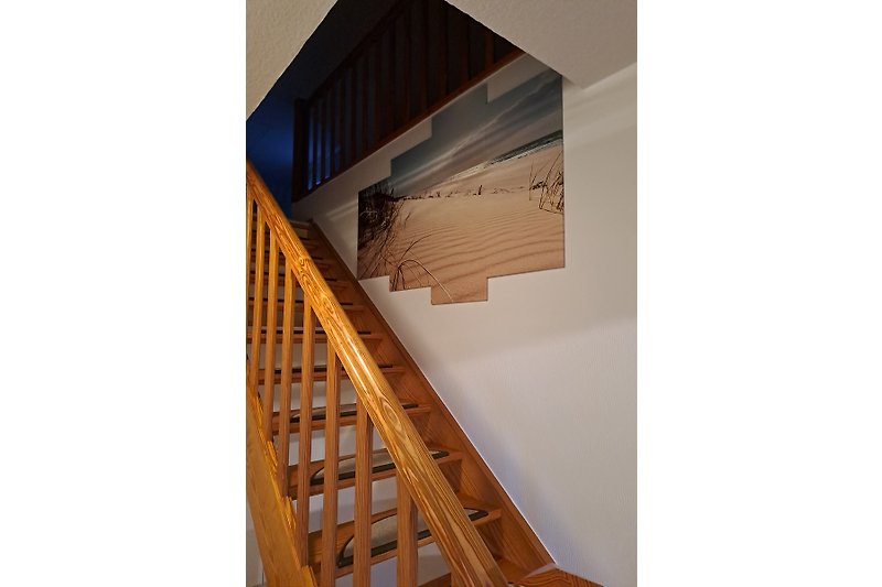 Eine stillvolle Holztreppe führt in den Wohn- und Schlafbereich.