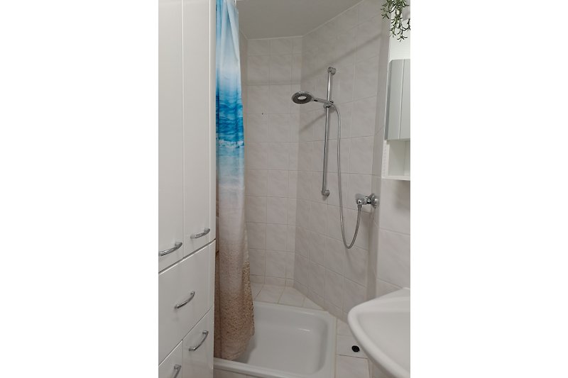 Modernes Badezimmer mit weißer Dusche.