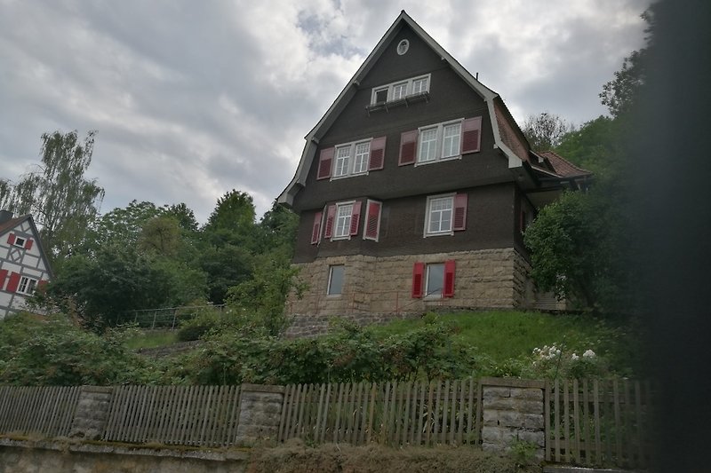 Historisches Stadthaus mit Blick auf die historische Altstadt+ umgeben von grüner Landschaft.