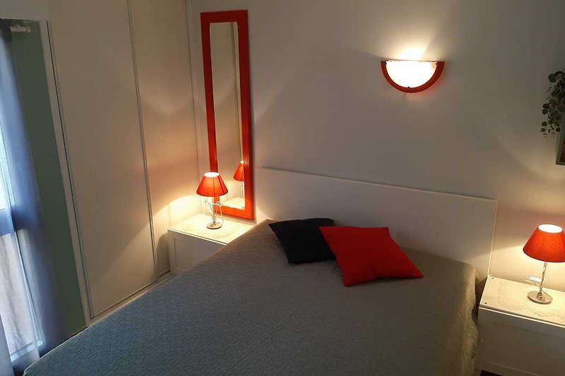 Gemütliches Schlafzimmer mit Holzboden und warmem Licht.