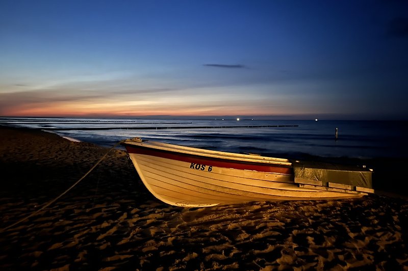 Schöne Küstenlandschaft mit Booten, Strand und Sonnenuntergang.