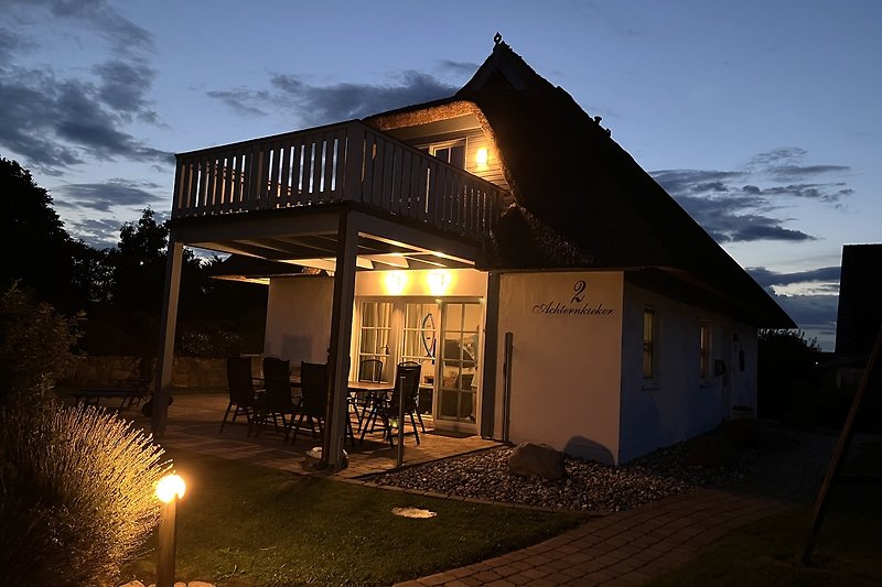 Gemütliches Ferienhaus mit idyllischem Abendlicht, umgeben von Natur.