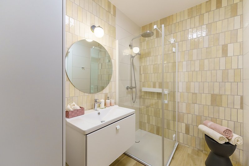 Piękna łazienka z designerskim lustrem i nowoczesnym wyposażeniem.