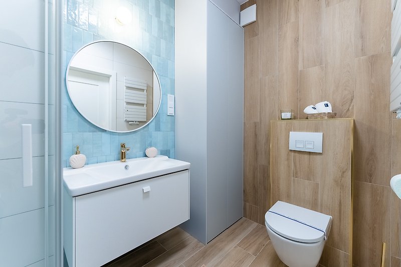 Piękna łazienka z lustrzaną szafką i fioletowymi dodatkami.