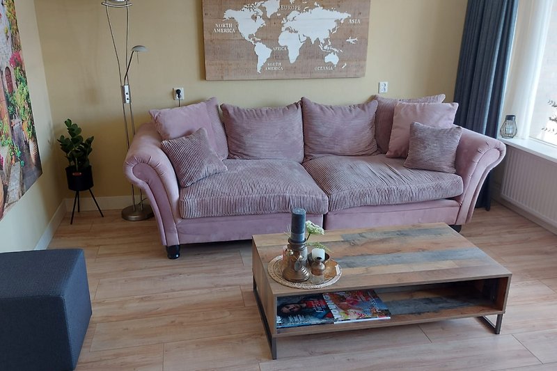 Stijlvolle woonkamer met paarse accenten en comfortabel meubilair.