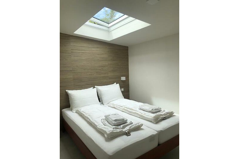 Schlafzimmer mit bequemem Bett, stilvoller Lampe und gemütlichem Interieur.