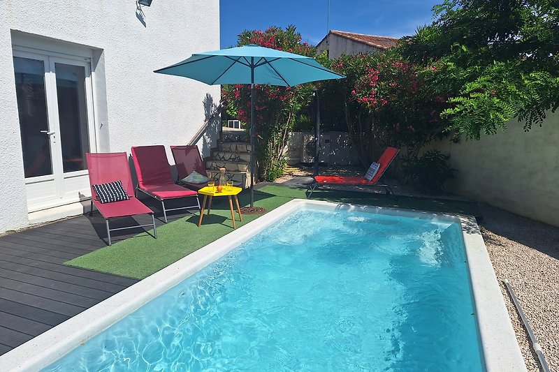 Privater Pool mit Palmen und stilvollen Gartenmöbeln.