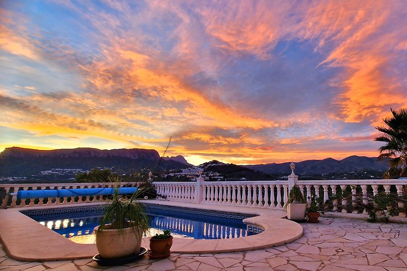 Sonnenuntergang über tropischem Pool mit Palmen