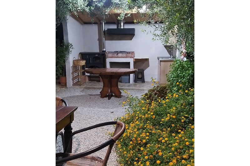 A beautiful BBQ  corner surrounded by olive trees and flowers
