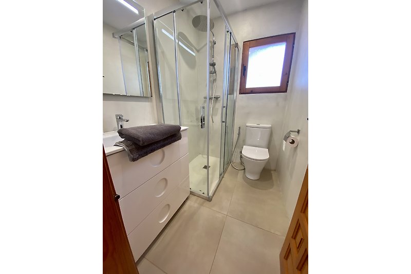 Een moderne badkamer met een comfortabele douche en luxe accessoires.