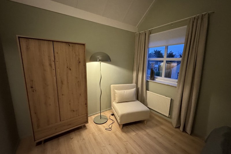 Gemütliches Schlafzimmer mit Holzfußboden und stilvoller Beleuchtung.