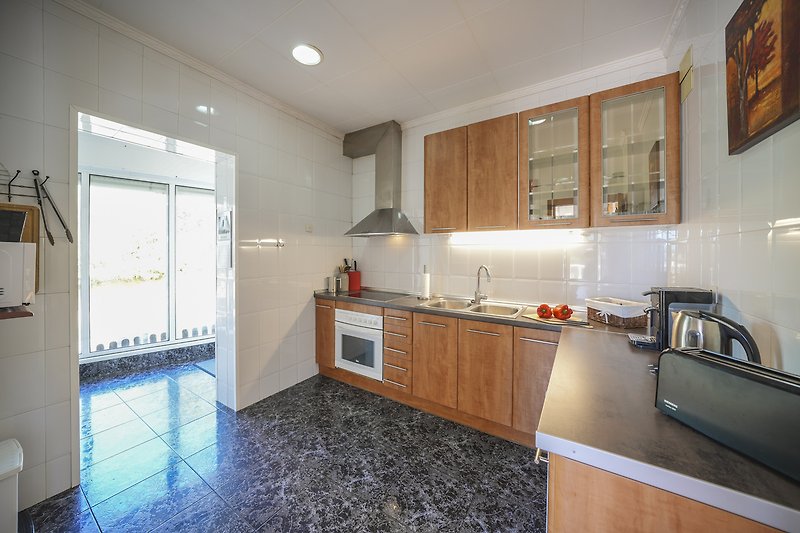 Moderne Küche mit stilvollen Schränken, Granit-Arbeitsplatte und hochwertigen Geräten.