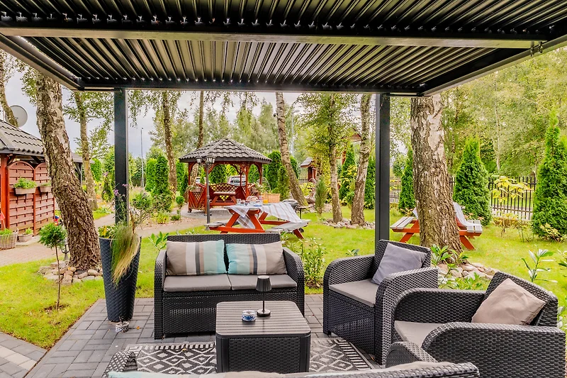 Entspannen Sie im Garten mit Pergola und komfortablen Möbeln.