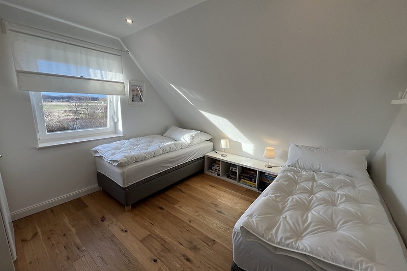 Modernes Schlafzimmer mit gemütlichen Betten und Spielen.