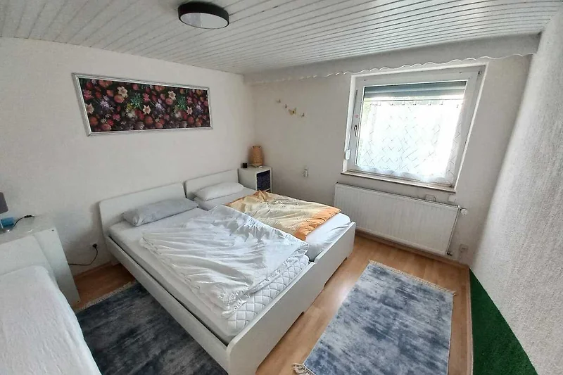Helles Schlafzimmer mit Holzdetails, bequemem Bett und Flachbild-TV.