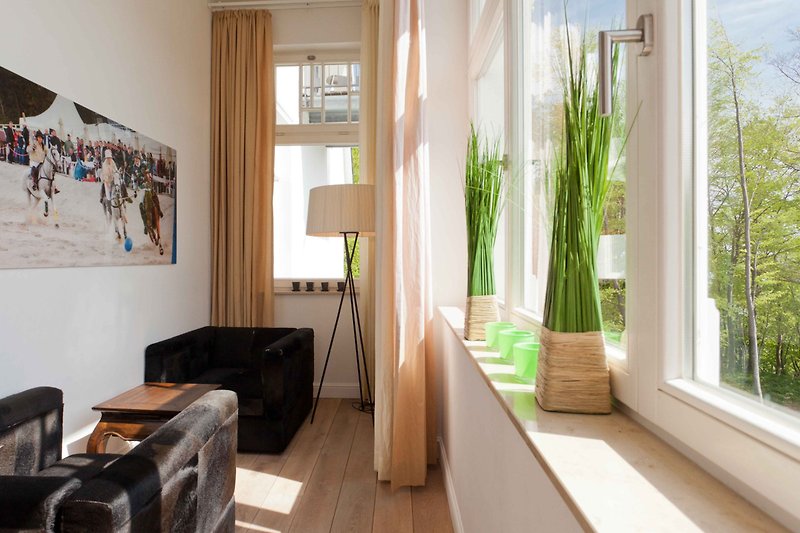 Stilvolles Wohnzimmer mit Pflanzen, Fenster und Holzboden.