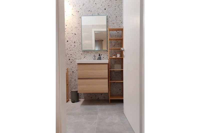 Elegantes Badezimmer mit modernem Spiegel und Armaturen.