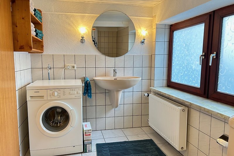 Badezimmer mit Waschmaschine und Fenster