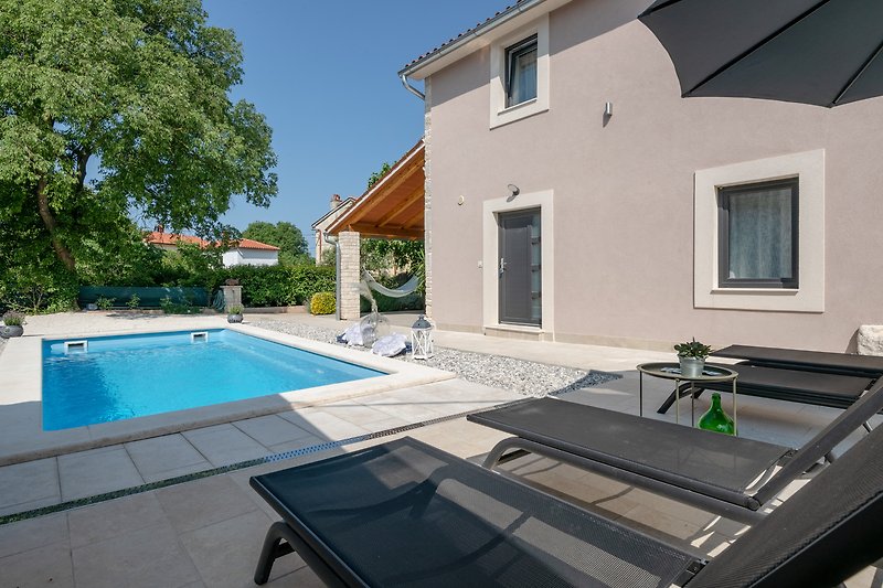 A beautiful house with a swimming pool and outdoor furniture.