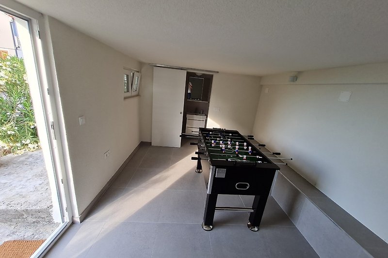 Game room with extra bathroom with washing machine
