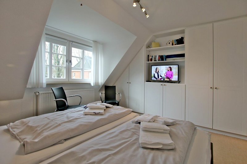 gemütliches Doppelbett mit TV und Kleiderschrank