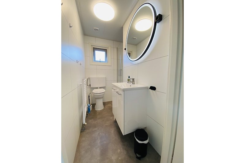 Schönes Badezimmer mit lila Fliesen, Spiegel und Waschbecken.