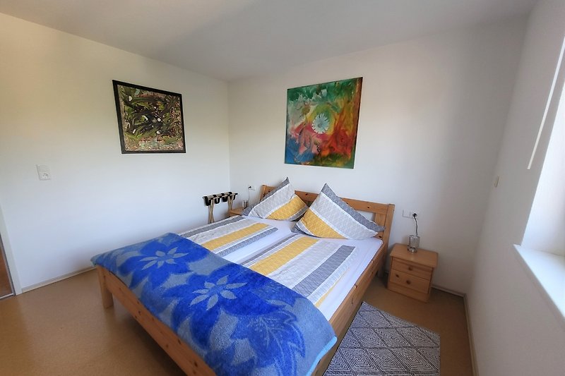 Schlafzimmer mit Kunst, Bett und Türen - perfekt für Ihren Urlaub!