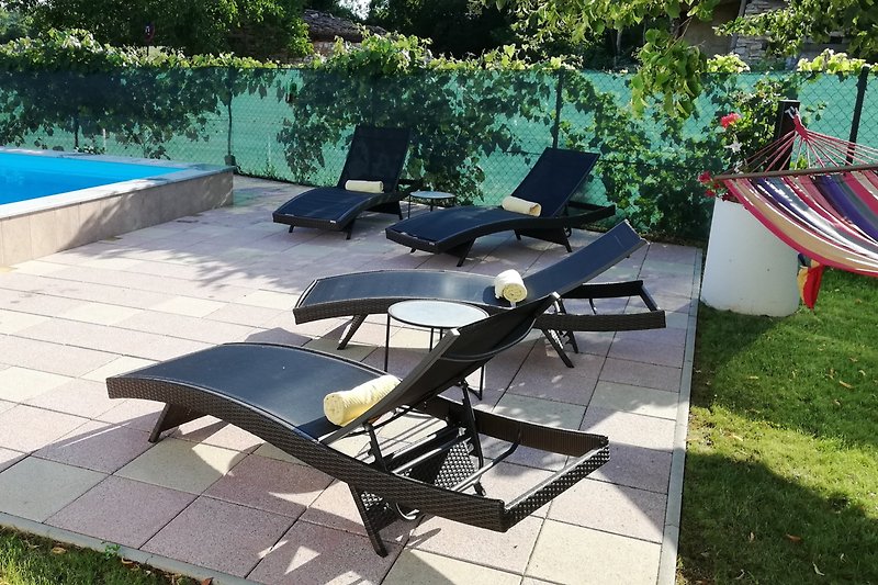 Entspannen Sie im grünen Schatten mit Outdoor-Möbeln und einem Tisch im Freien.