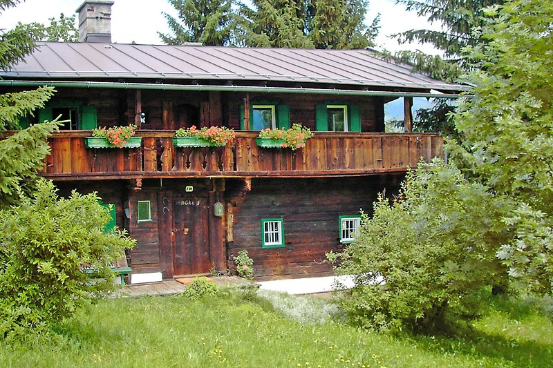 Traditionelles Haus mit Holzdach und schönem Garten.