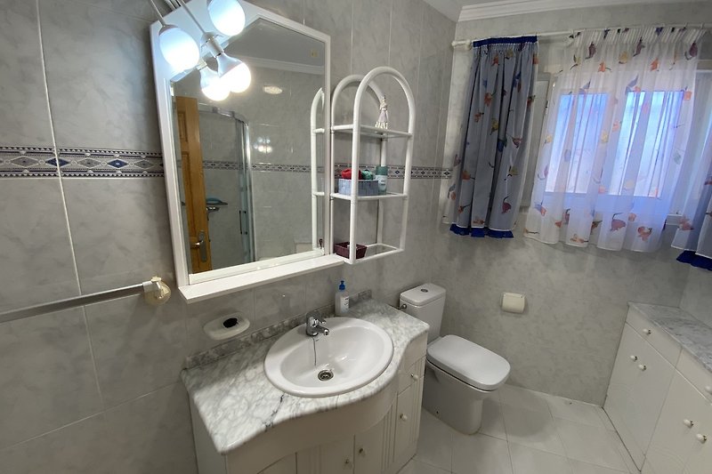 Schönes Badezimmer mit lila Fliesen und stilvoller Beleuchtung.