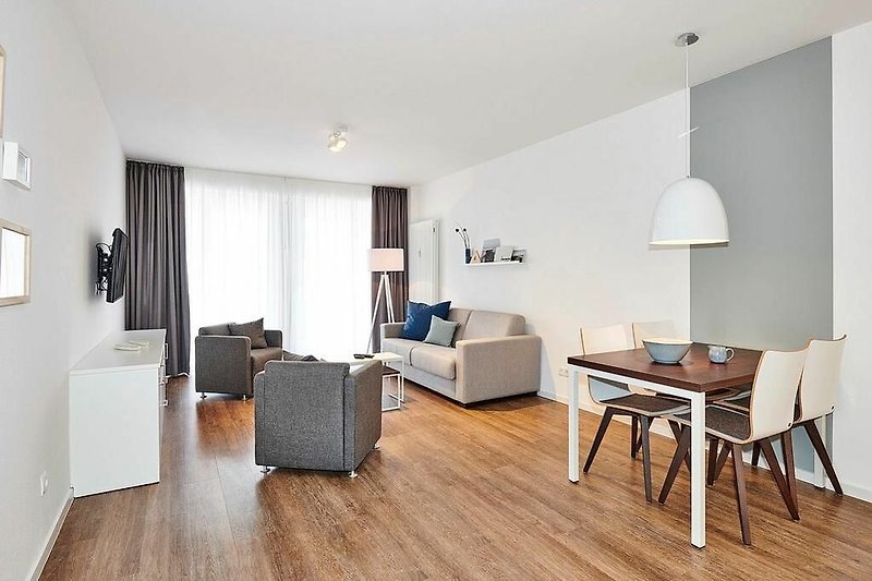 Wohn-Essbereich mit Couch, Sessel und Esstisch