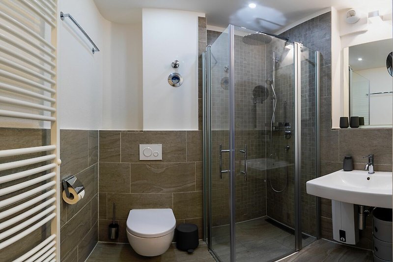 Badezimmer mit Dusche, Waschtisch, WC und Spiegel
