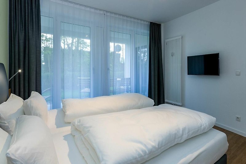 Schlafzimmer mit Doppelbett, Flatscreen-TV und Zugang zur Terrasse