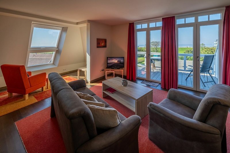 Wohn-Essbereich mit Couch und Zugang zum Balkon