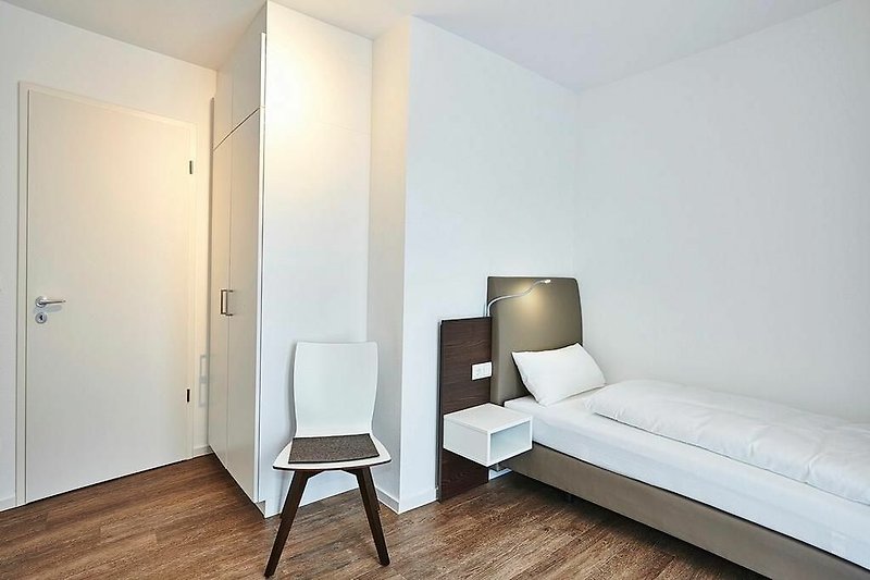 Schlafzimmer mit zwei Einzelbetten, Stuhl und Kleiderschrank