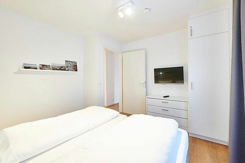 Schlafbereich mit Doppelbett und Flatscreen TV