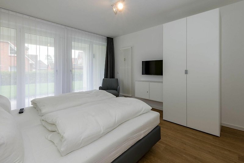 Schlafzimmer mit Doppelbett, Kleiderschrank und Flatscreen TV