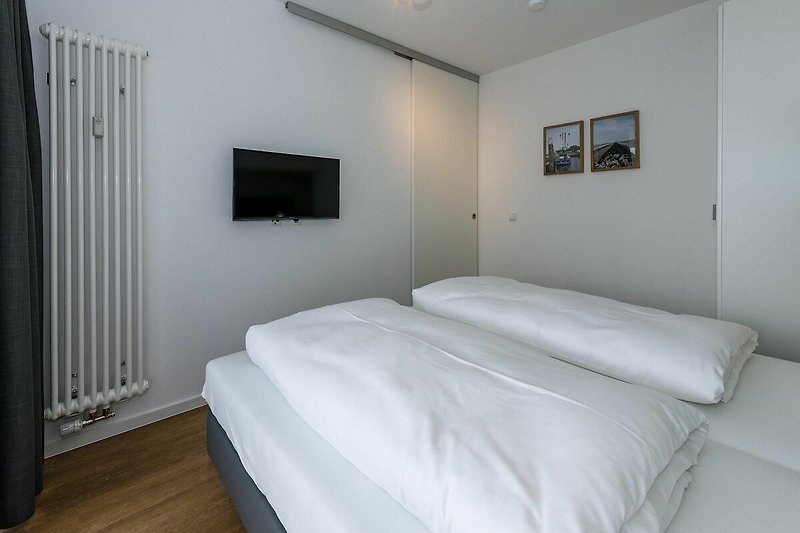 Schlafzimmer mit Doppelbett, Kleiderschrank und Flatscreen TV