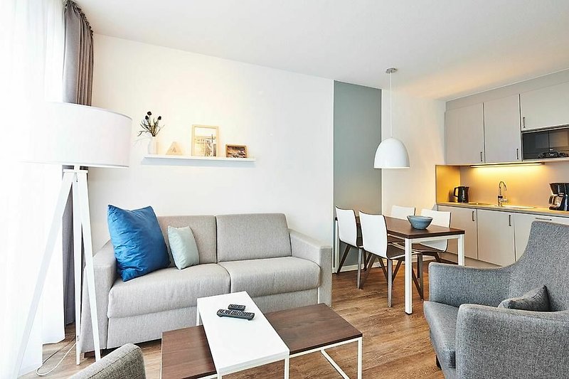 Wohn/Essbereich mit Couch, Sesseln, Esstisch und Küchenzeile