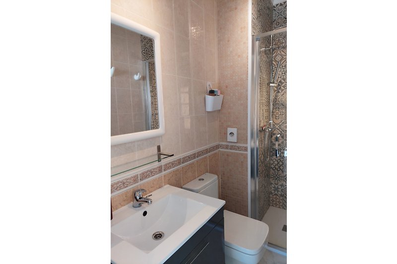 Prachtige badkamer met  marmeren tegels en glazen douchewand.