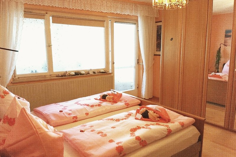 Gemütliches Schlafzimmer mit stilvollem Holzbett und schöner Fensteraussicht.