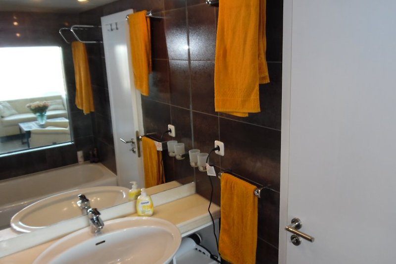 Badkamer met grote wastafel en grote spiegel