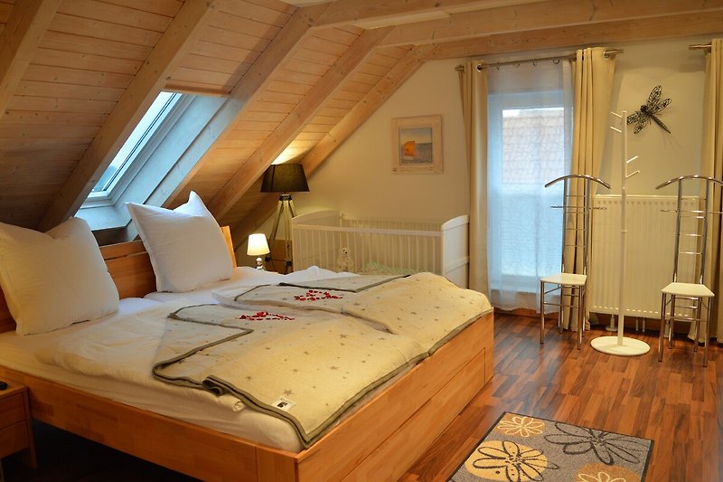 Schlafzimmer mit Doppelbett u. Babybett oben