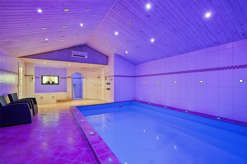 Elegantes Interieur mit stilvollem Licht und einladendem Pool.