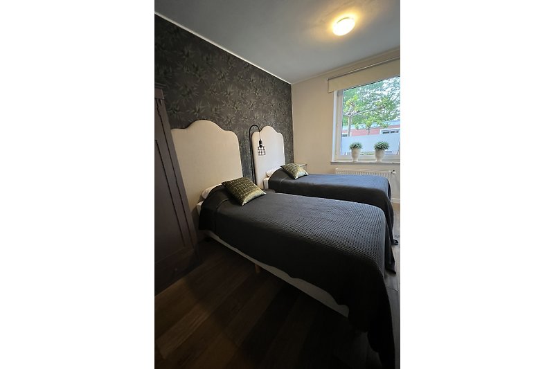Comfortabele kamer met houten vloer en daglicht.