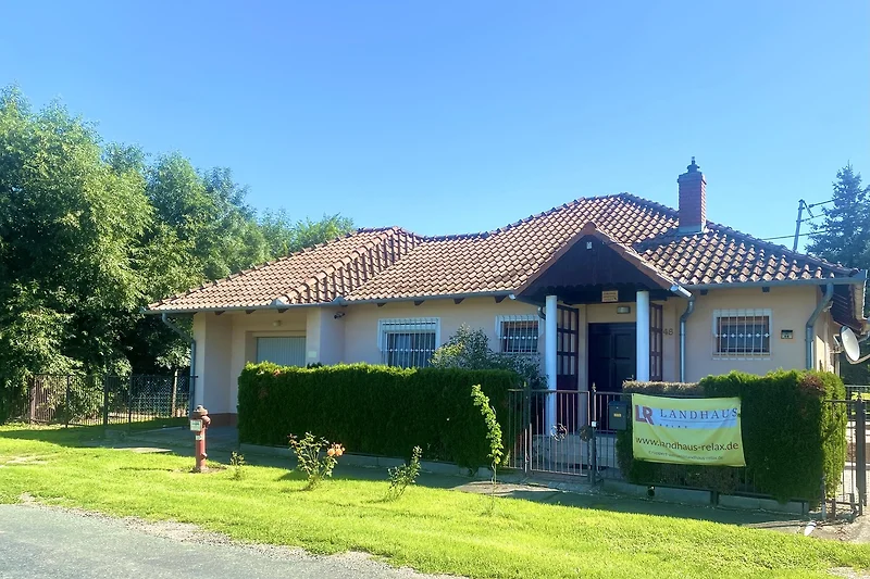 Ein charmantes Haus mit einem gepflegten Garten und einer malerischen Landschaft.
